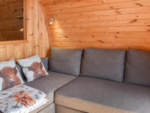 a gray couch in a room with wooden walls at Manx View-Uk1396 in Corney
