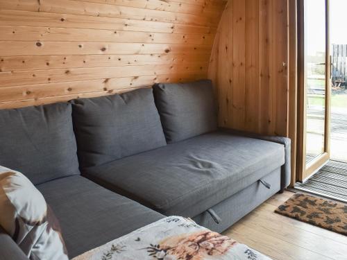 a couch in a room with a wooden wall at Black Coombe-Uk1392 in Corney