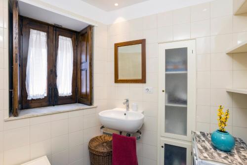 a white bathroom with a sink and a mirror at Casa Edera - Villa Storica in Viagrande
