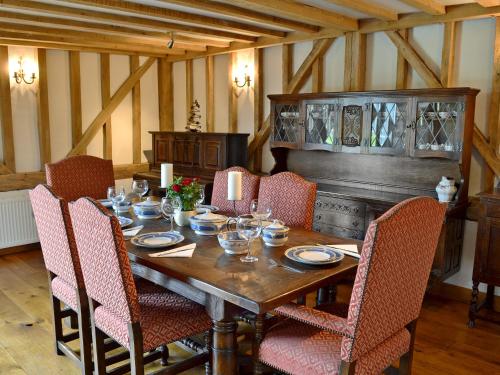 a dining room with a wooden table and chairs at Romden Barn in Smarden