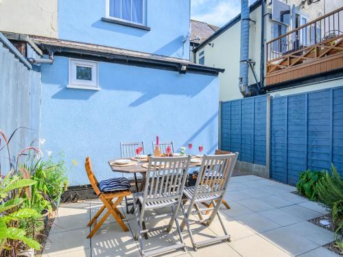 a patio with a table and chairs and a blue wall at Beachcombers Retreat in Felixstowe