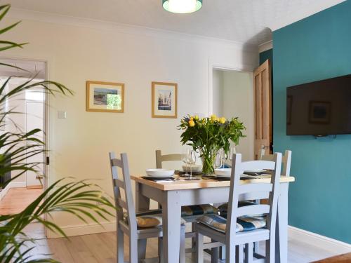 a dining room with a white table and chairs at Dragonfly Cottage in Beverley