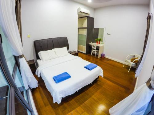 a bedroom with a white bed with blue pillows on it at Luxury Condominium at Loft Imago in Kota Kinabalu