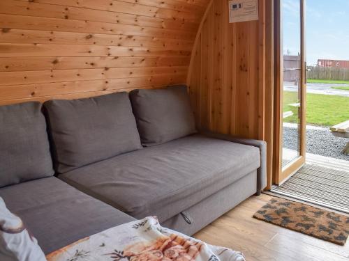a couch in a tiny house with a window at Withy Bottom-Uk1393 in Corney