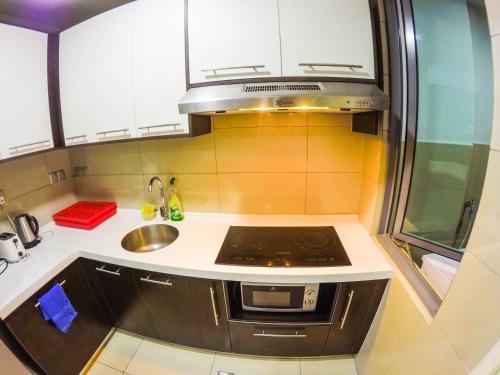a small kitchen with a sink and a stove at Luxury Condominium at Loft Imago in Kota Kinabalu