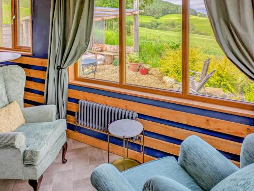 a living room with chairs and a large window at Cowlas in Aberhosan