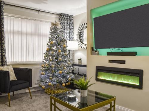 a living room with a christmas tree and a fireplace at Wharfdale Lodge in Thornton