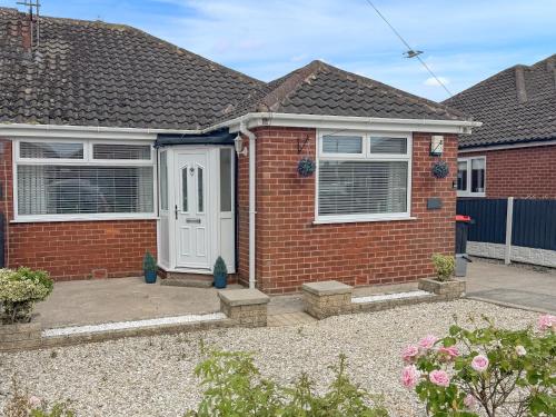 a red brick house with a white door at Wharfdale Lodge in Thornton