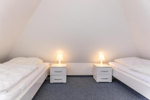 two beds in a room with two lamps on them at Ferienhaus 50007 in Carolinensiel