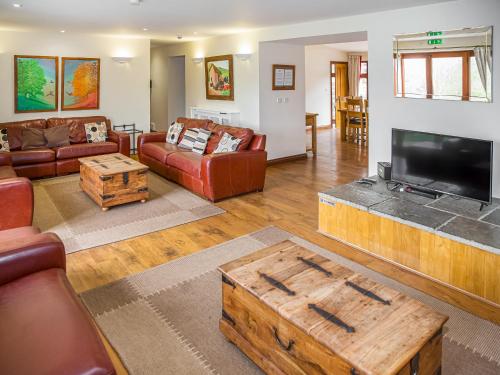 a living room with couches and a flat screen tv at The Cider Barn - Hggl in Luton