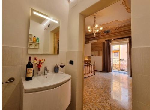 a bathroom with a sink with a bottle of wine at Antica Dimora Donna Emma in Carini