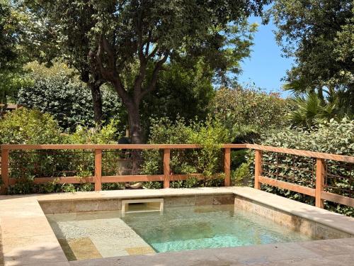 a small pool of water next to a wooden fence at Résidence Guddelmoni, Piscines chauffées in Propriano
