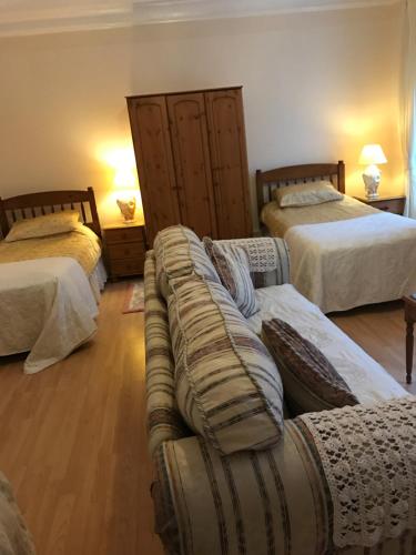 a living room with two beds and a couch at Brown's Guest House in Peterhead