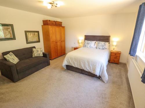 a bedroom with a bed and a couch at 80 Pentney Lakes in King's Lynn