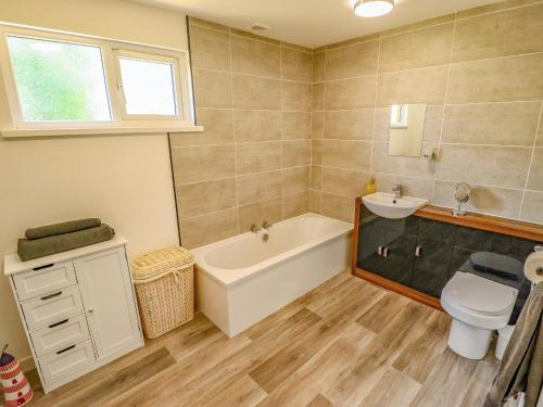 a bathroom with a tub and a toilet and a sink at 80 Pentney Lakes in King's Lynn