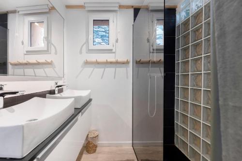 a bathroom with two sinks and a glass shower at Chalet Villarenger in Saint-Martin-de-Belleville