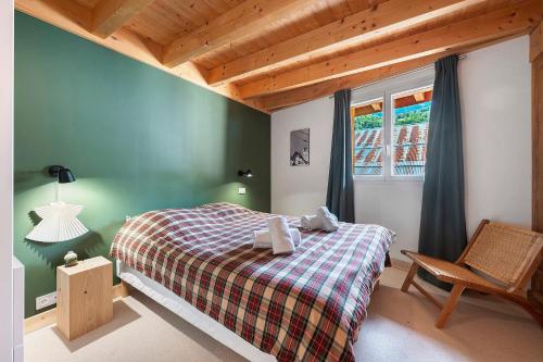 a bedroom with a bed and a chair and a window at Chalet Villarenger in Saint-Martin-de-Belleville