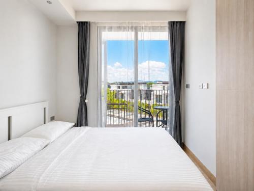 a bedroom with a bed and a large window at Sky Park Laguna 2BR Condo with Balcony in Laguna Phuket