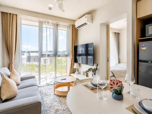 a living room with a couch and a table at Sky Park Laguna 2BR Condo with Balcony in Laguna Phuket