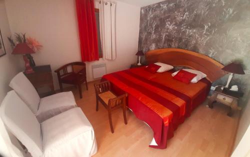 a bedroom with a red bed and a chair and a chair at Ô Reflet du Lac in Groléjac