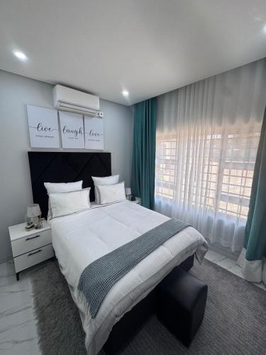 a bedroom with a large bed and a window at MAITA Apartments - Silverest, Lusaka in Chongwe