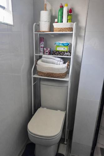 a bathroom with a white toilet and some towels at MAITA Apartments - Silverest, Lusaka in Chongwe