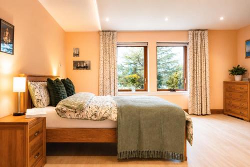 a bedroom with a bed and a window at Lakeside Lodge, Views, Hot Tub & Fully Accessible in Elgin