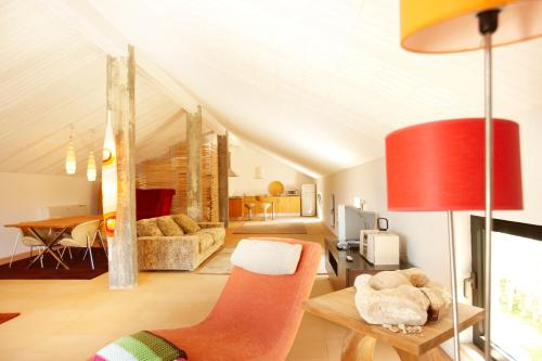 ein Wohnzimmer mit einer roten Lampe und einer Couch in der Unterkunft Quinta Do Miguel in Aldeia do Meco