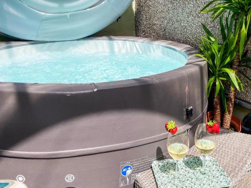 a hot tub with two glasses of wine on a table at Mushroom Cottage in Ferndale