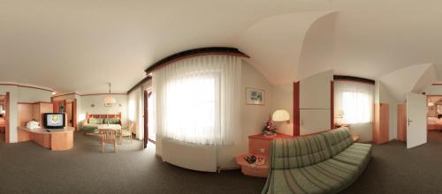 a living room with a large window and a couch at Das-Schmidt Privathotel in Mörbisch am See