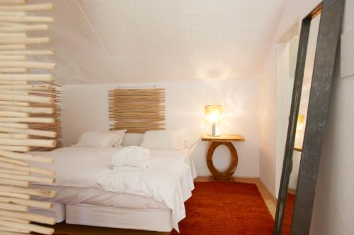 a bedroom with two beds and a table with a lamp at Quinta Do Miguel in Aldeia do Meco