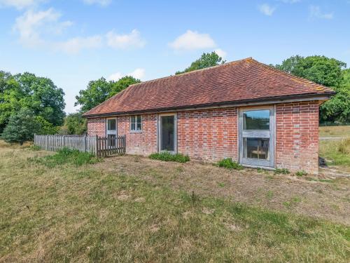 a brick house in a field at Coblye Barn in Battle