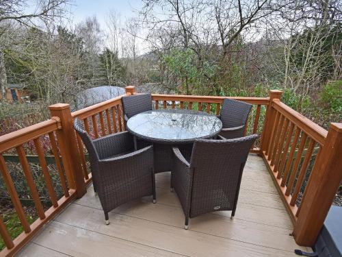 a patio with a table and chairs on a deck at Bluebird Lodge 2 - Uk50932 in High Nibthwaite
