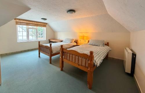 a bedroom with two beds and a window at No 1 The Martins in Southwold