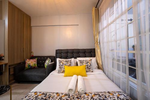 a bedroom with a large bed with a yellow pillow at Studio Apartment with balcony in Ngara in Nairobi