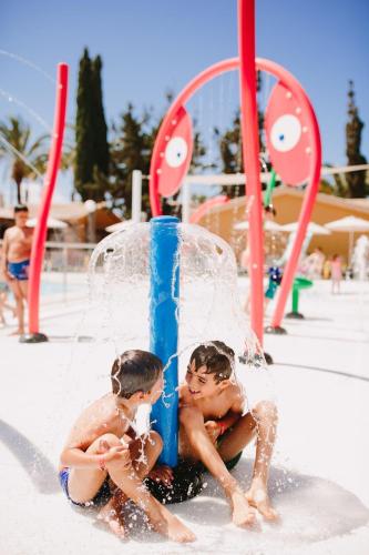 two young children playing in a water park at Suites & Villas by Dunas in Maspalomas