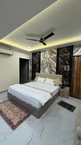 a bedroom with a large bed with a ceiling fan at Hotel Gatik Inn in Sānāwad