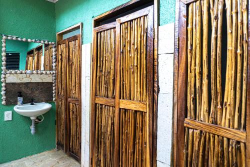 a bathroom with wooden doors and a sink at Pirita Beach House in Santa Ana