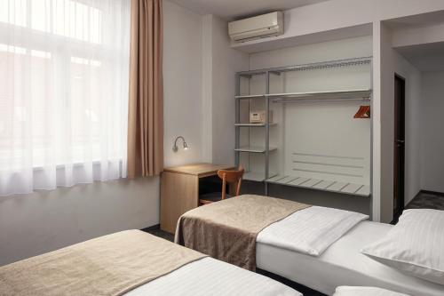 a hotel room with two beds and a window at Hotel Ambiance in Prague