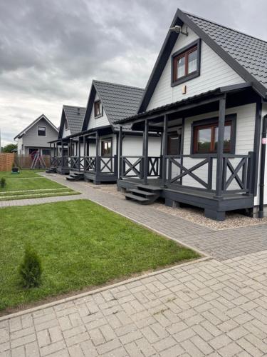 a row of houses with grass in front of them at Domki Prima Baltic in Sarbinowo