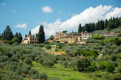 a village on a hill with trees and houses at Fattoria di Maiano in Fiesole