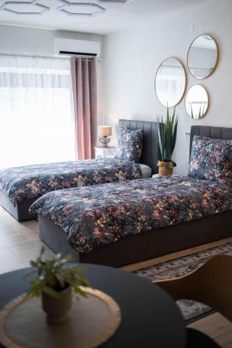 a bedroom with two beds and a table at Apartman NOA in Novska