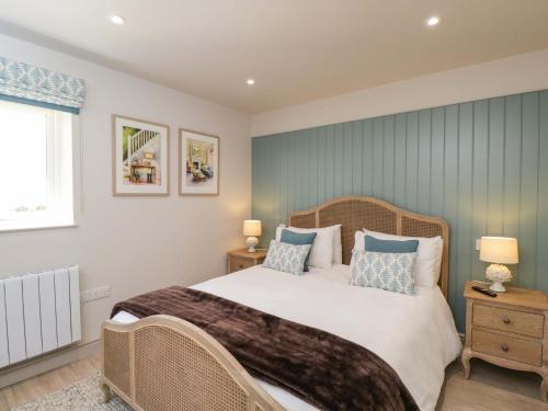 a bedroom with a large bed with blue walls at Poppy Patch in Bicester