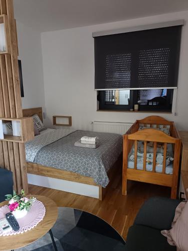 a small room with two beds and a table at Orca Apartman in Jagodina
