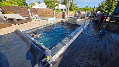 a person in a swimming pool with a pool at Entre Mer et Volcan ,piscine chauffée au tampon in Bel Air