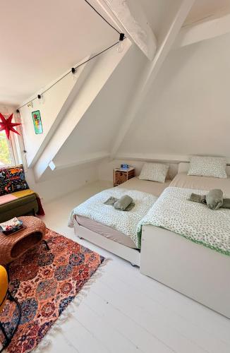 two beds in a room with a attic at Asanzo Historic Attic-Traditional Norwegian Home & Warm Indian Hospitality in Stavanger