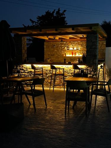 a patio with tables and chairs at night at Ninemia Naxos Suites in Naxos Chora