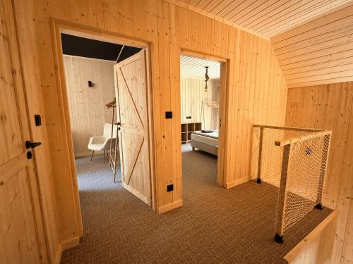a wooden room with a door and a room with a bed at Leśna Przystań apartamenty dwupoziomowe nad jeziorem in Węgorzewo