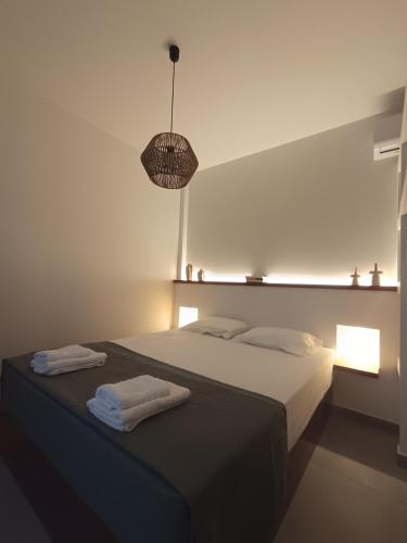 a bedroom with a bed with two towels on it at IOVI Tinos II in Agios Sostis