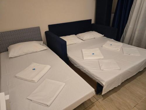 two beds in a room with white towels on them at Apartment Natasha in Paralia Katerinis